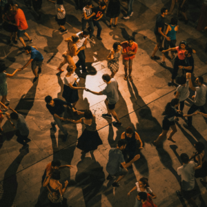 Scène de danse collective lors d’un événement culturel, illustrant l’engagement et la participation dans le tissu associatif culturel.