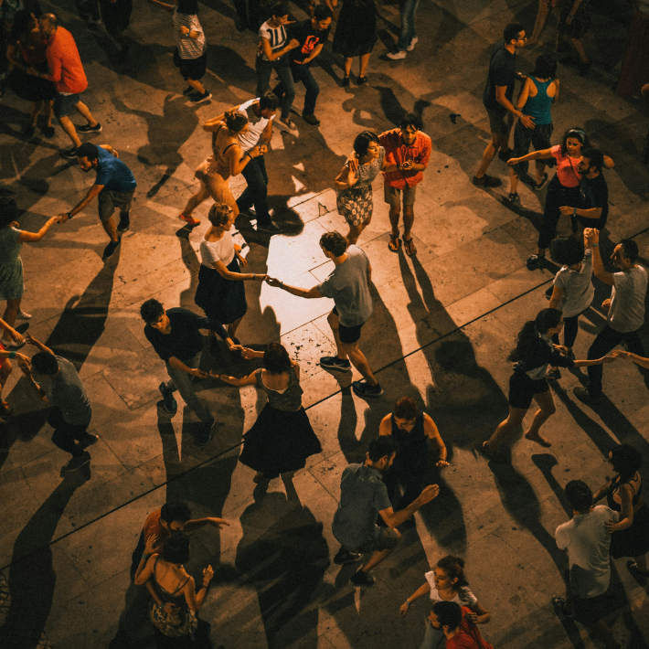 Scène de danse collective lors d’un événement culturel, illustrant l’engagement et la participation dans le tissu associatif culturel.