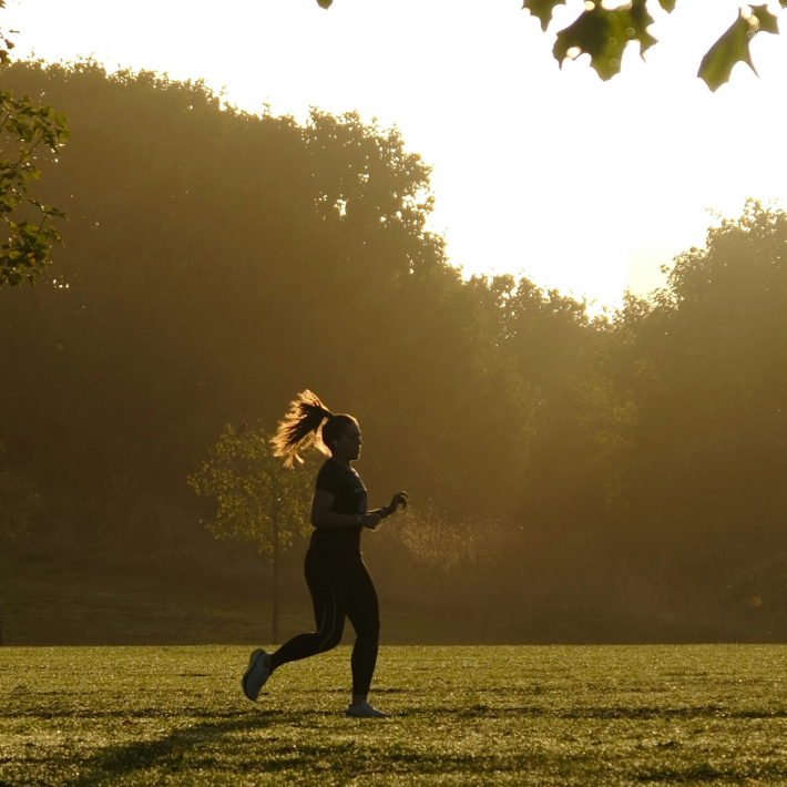 Femme courant en plein air dans un parc, illustrant l’évolution des pratiques sportives et la montée des activités physiques autonomes